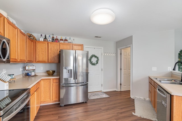 kitchen featuring visible vents, light countertops, appliances with stainless steel finishes, dark wood-style floors, and a sink