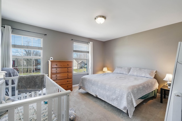 bedroom with baseboards and light colored carpet