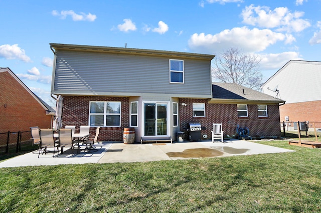 back of property featuring a yard, a patio, brick siding, and fence