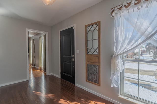 foyer featuring baseboards and dark wood-style floors