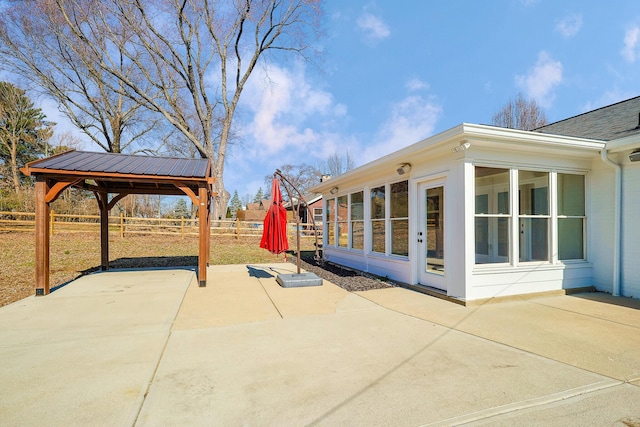 view of patio / terrace with fence and a sunroom