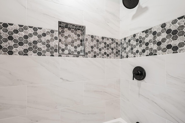 interior details featuring a tile shower