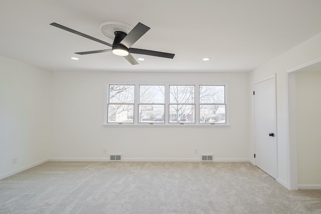 unfurnished room featuring plenty of natural light, visible vents, and light carpet