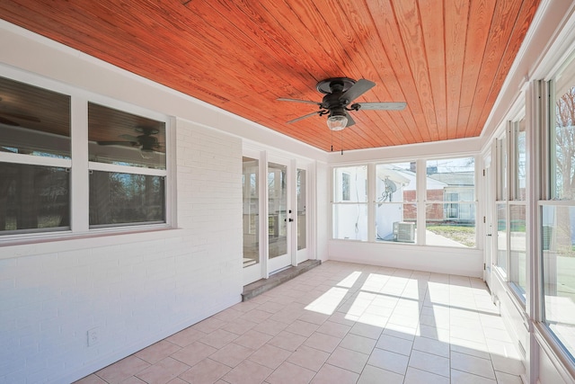 unfurnished sunroom featuring wooden ceiling and ceiling fan