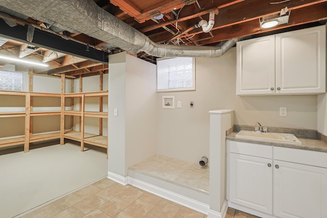 basement featuring baseboards and a sink