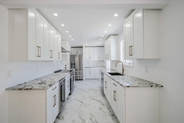 kitchen featuring white cabinetry, marble finish floor, appliances with stainless steel finishes, and a sink