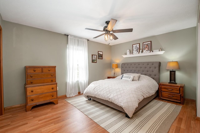 bedroom with ceiling fan, baseboards, and light wood-style floors