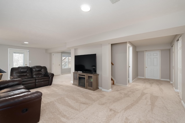 carpeted living room with stairway, baseboards, and plenty of natural light