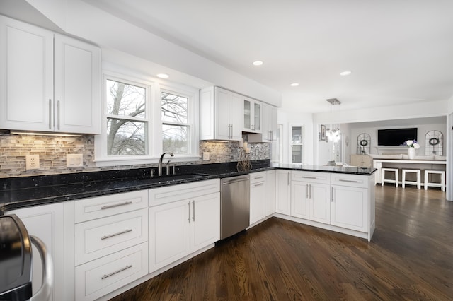 kitchen featuring a sink, dark wood finished floors, white cabinetry, a peninsula, and dishwasher