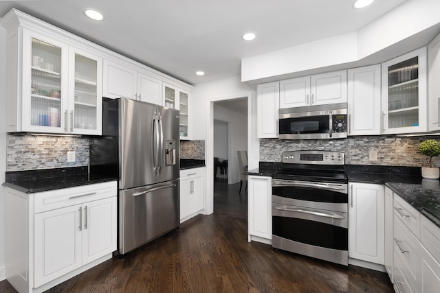 kitchen with stainless steel appliances, dark wood-type flooring, decorative backsplash, and white cabinetry