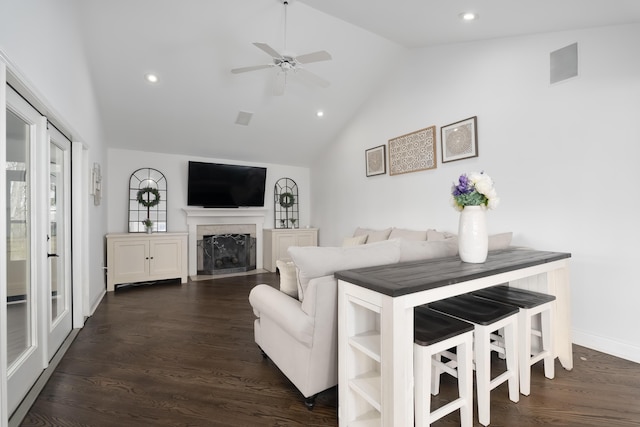 living room with lofted ceiling, a fireplace, dark wood-style flooring, and ceiling fan