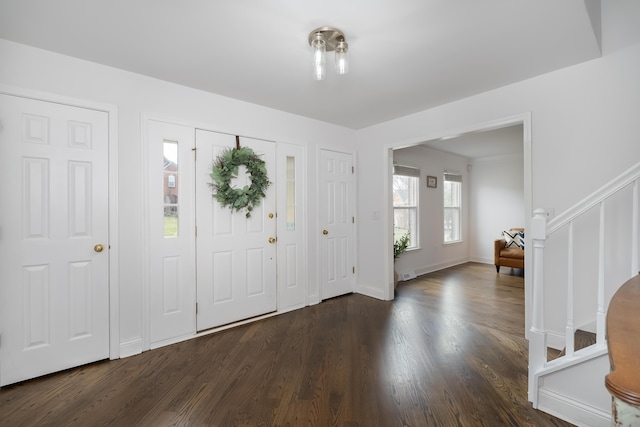 foyer entrance with dark wood-style floors and baseboards