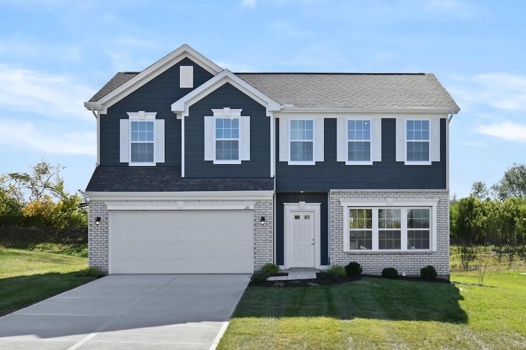 view of front facade featuring a front yard, concrete driveway, brick siding, and a garage