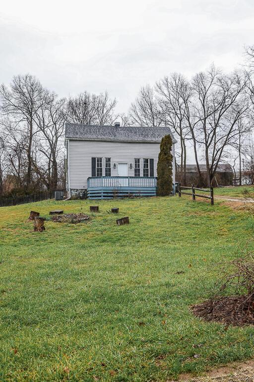 view of front of house featuring a front lawn, fence, and a wooden deck