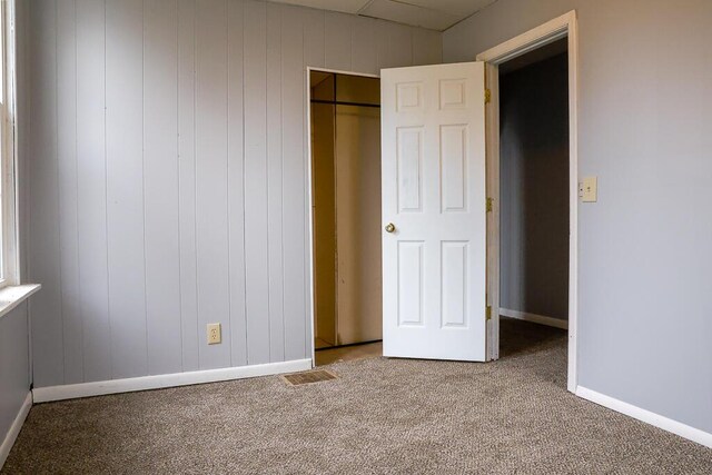 unfurnished bedroom featuring carpet flooring, baseboards, visible vents, and a closet