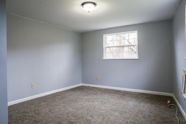 empty room featuring carpet and baseboards
