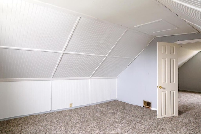 additional living space with visible vents, carpet, and vaulted ceiling
