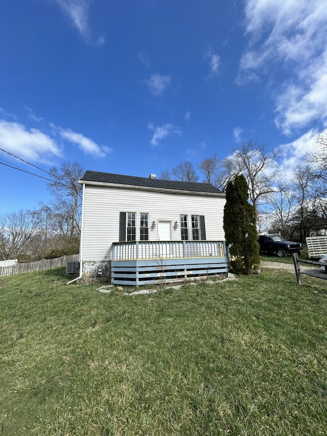 view of front of property featuring a front lawn, fence, central AC, and a wooden deck