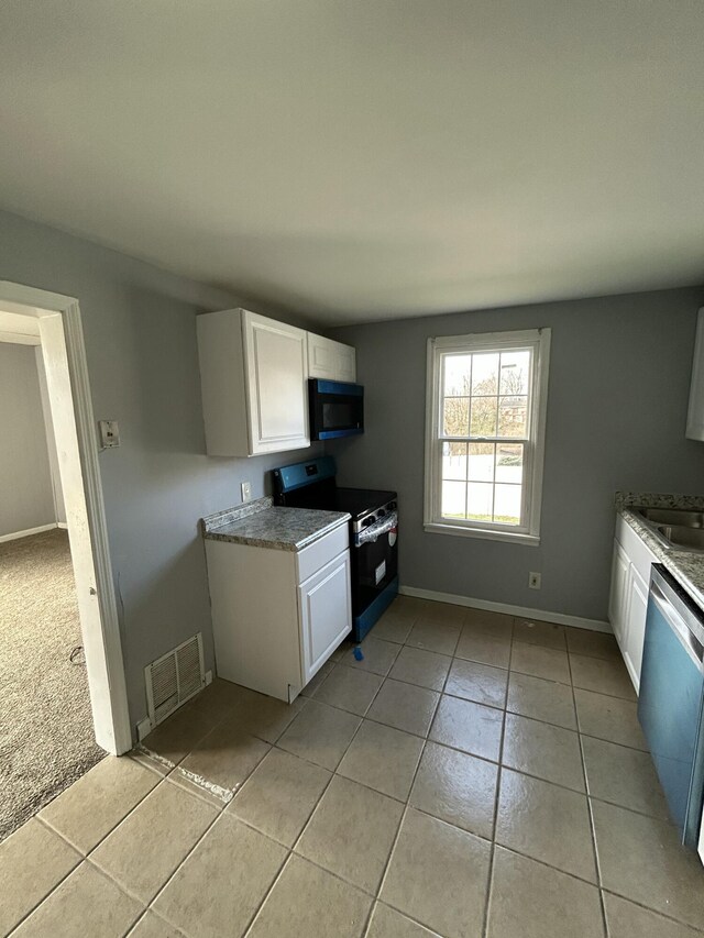 kitchen featuring light tile patterned floors, visible vents, white cabinetry, and black appliances