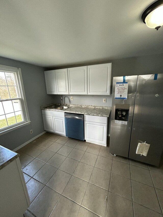 kitchen featuring tile patterned floors, white cabinets, baseboards, and stainless steel appliances