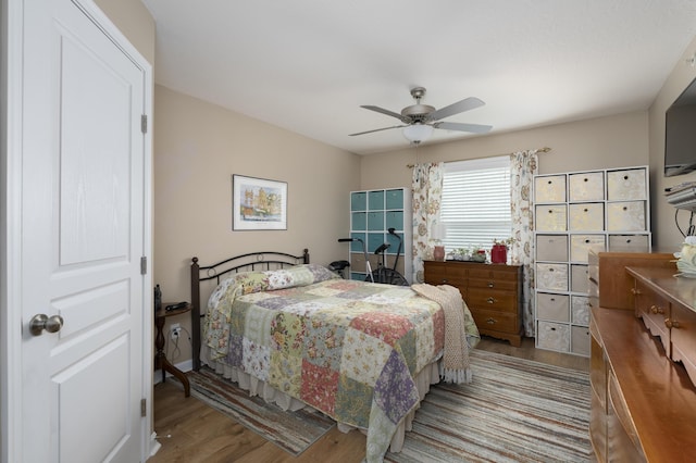 bedroom featuring wood finished floors, baseboards, and ceiling fan