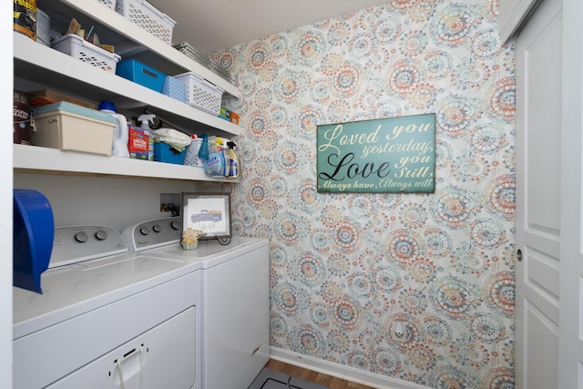 washroom featuring washer and dryer, wood finished floors, wallpapered walls, baseboards, and laundry area