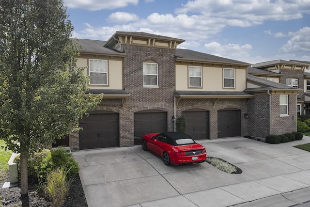 view of front of home with a garage, brick siding, and driveway