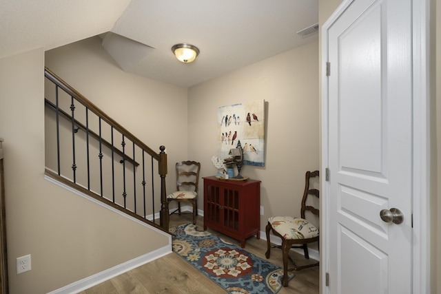 foyer entrance with visible vents, stairs, baseboards, and wood finished floors