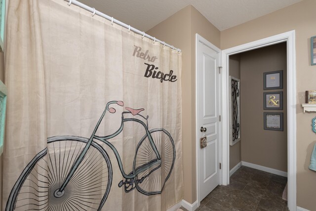 bathroom with baseboards and a textured ceiling