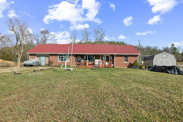 rear view of property with a lawn, metal roof, and brick siding