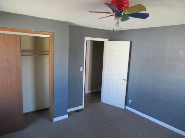 unfurnished bedroom with a closet, a ceiling fan, baseboards, and carpet floors