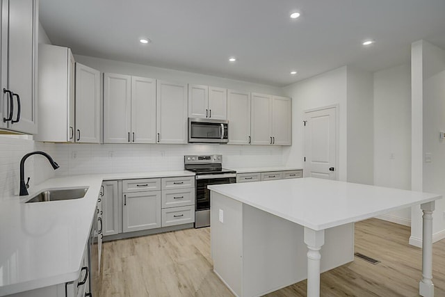 350 Foxhunt Dr, Walton, KY 41094 - kitchen featuring stainless steel appliances, a sink, light wood-style flooring, a breakfast bar area, and recessed lighting
