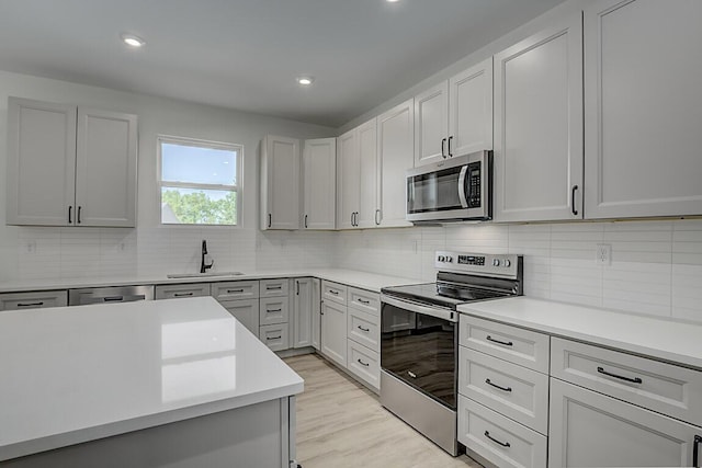 350 Foxhunt Dr, Walton, KY 41094 - kitchen with appliances with stainless steel finishes, a sink, light countertops, backsplash, and recessed lighting