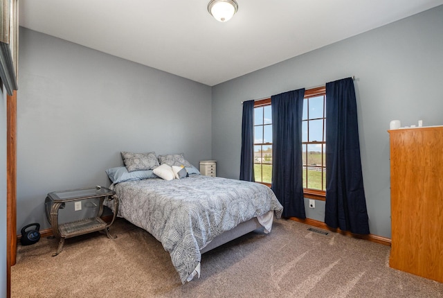 carpeted bedroom featuring baseboards and visible vents