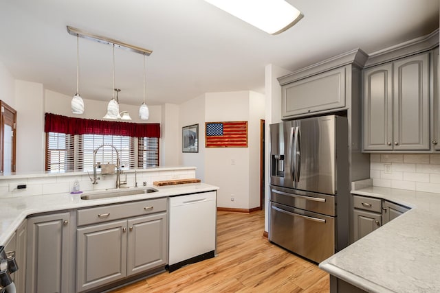 kitchen featuring a sink, gray cabinets, stainless steel fridge, and dishwasher