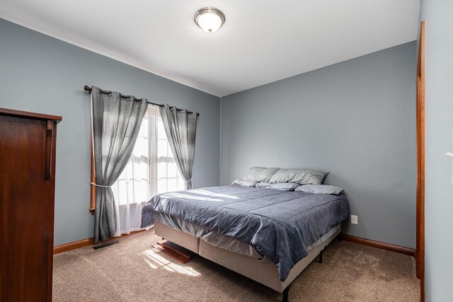 carpeted bedroom featuring baseboards and visible vents
