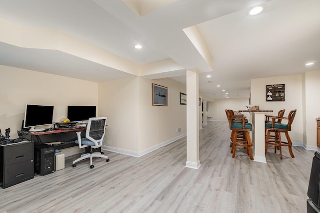 office area featuring baseboards, light wood-style floors, and indoor bar