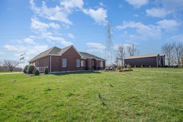 view of side of home featuring a lawn and brick siding