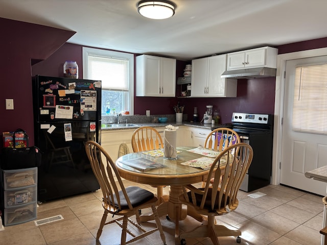 98 S Main St, Dry Ridge, KY 41035 - kitchen featuring freestanding refrigerator, light tile patterned flooring, under cabinet range hood, and electric range oven