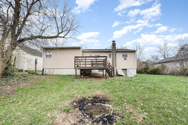 rear view of house with a chimney, a wooden deck, and a yard