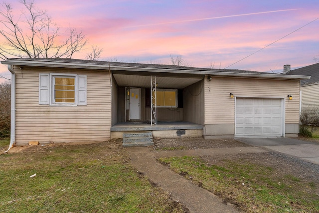 ranch-style home featuring a garage, concrete driveway, and a porch