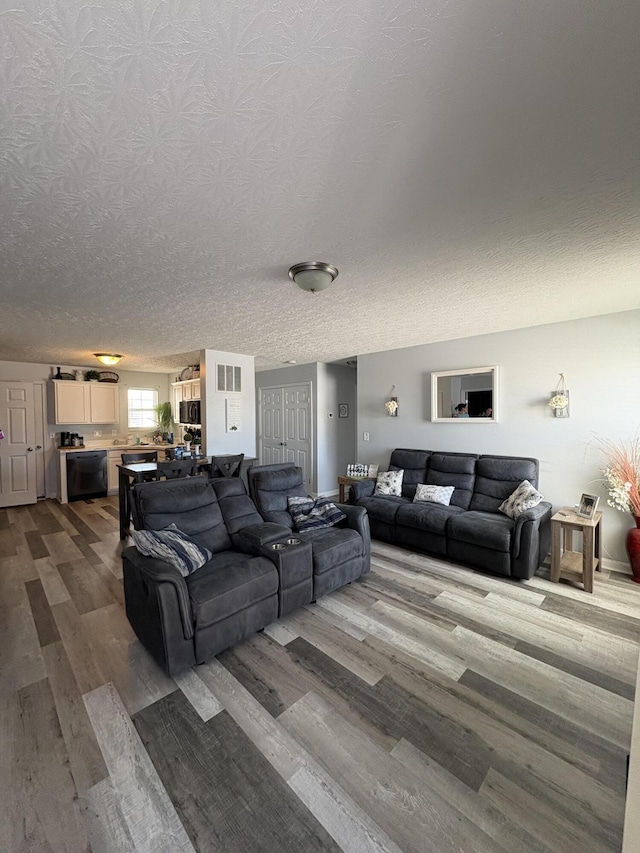 living room with a textured ceiling and dark wood finished floors