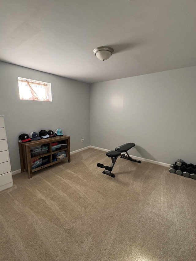 exercise room with baseboards and carpet