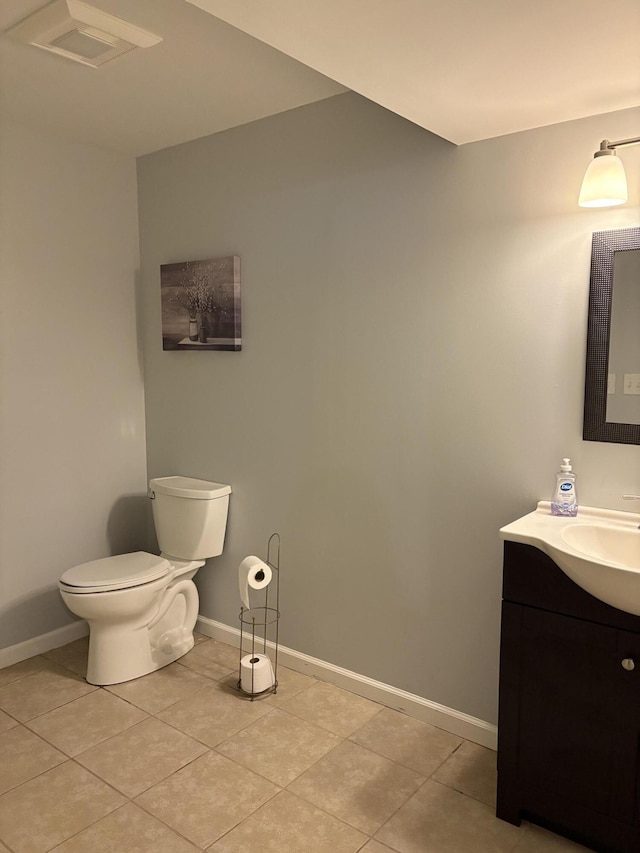 bathroom featuring toilet, tile patterned flooring, baseboards, and vanity