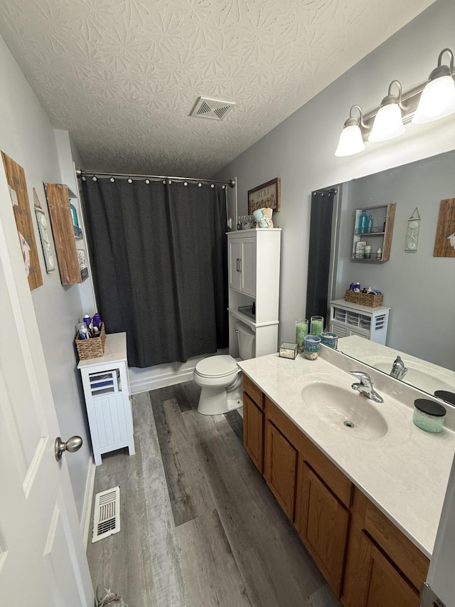 full bath featuring a shower with curtain, wood finished floors, visible vents, and vanity