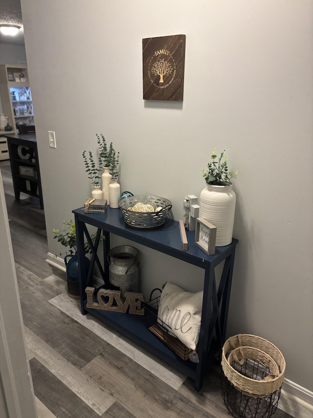 hallway featuring baseboards and wood finished floors
