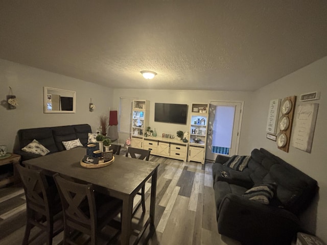 dining room with wood finished floors and a textured ceiling