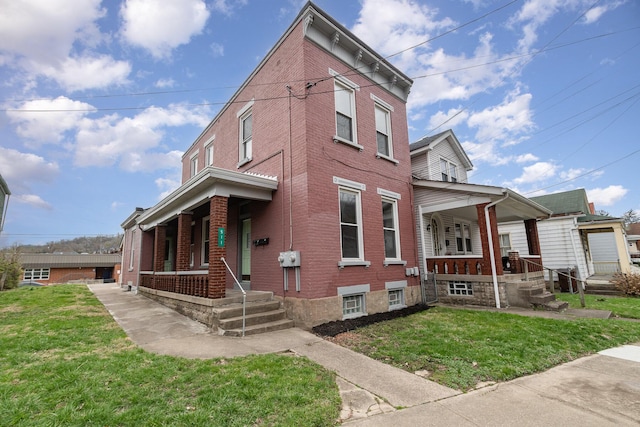 511 Highland Pike, Covington, KY 41014 - view of front of house featuring covered porch, brick siding, and a front lawn