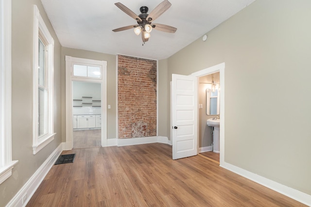 511 Highland Pike, Covington, KY 41014 - unfurnished bedroom featuring baseboards, visible vents, ensuite bathroom, and wood finished floors