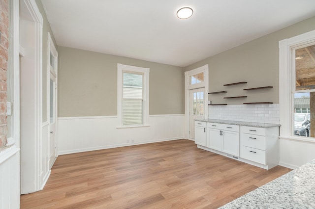 511 Highland Pike, Covington, KY 41014 - kitchen with a wainscoted wall, open shelves, light stone countertops, white cabinets, and light wood-style floors